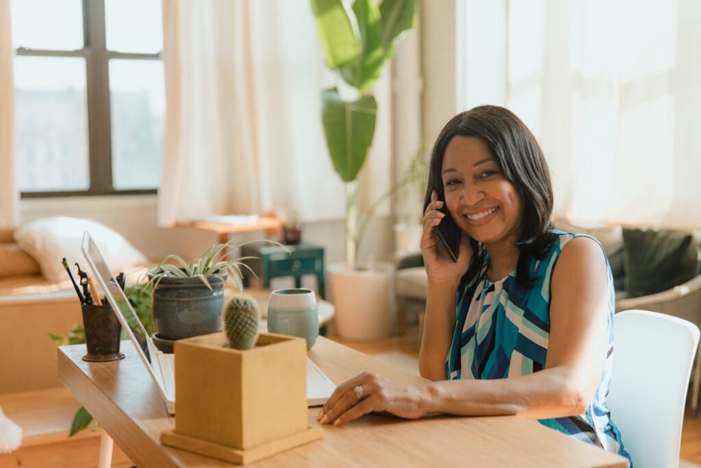 Smiling woman on a phone call at her desk at home