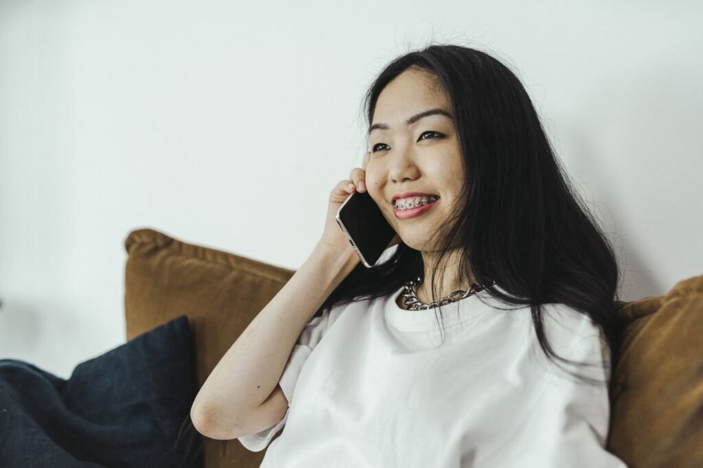 Smiling woman chatting on her phone while relaxing on a sofa