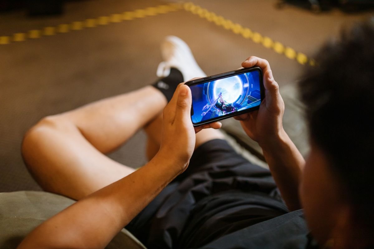 Person gaming on a smartphone held sideways
