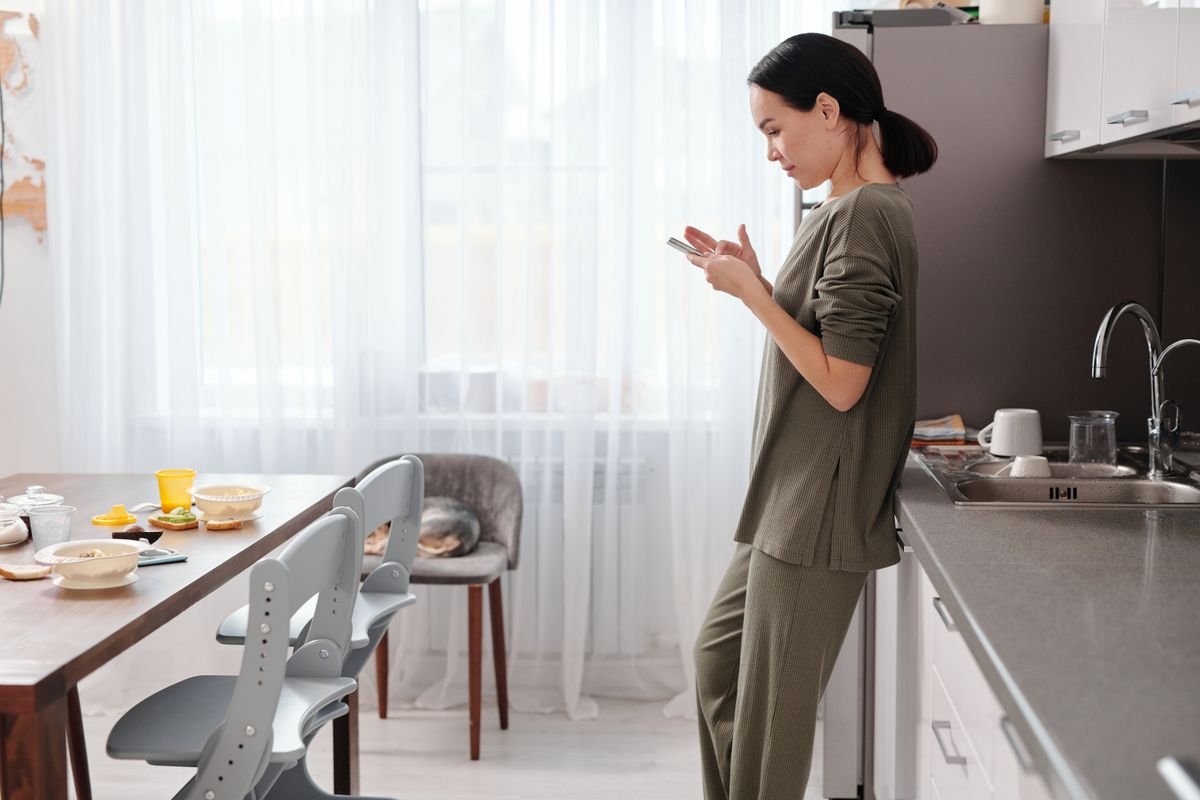 Woman using her smartphone in a modern kitchen